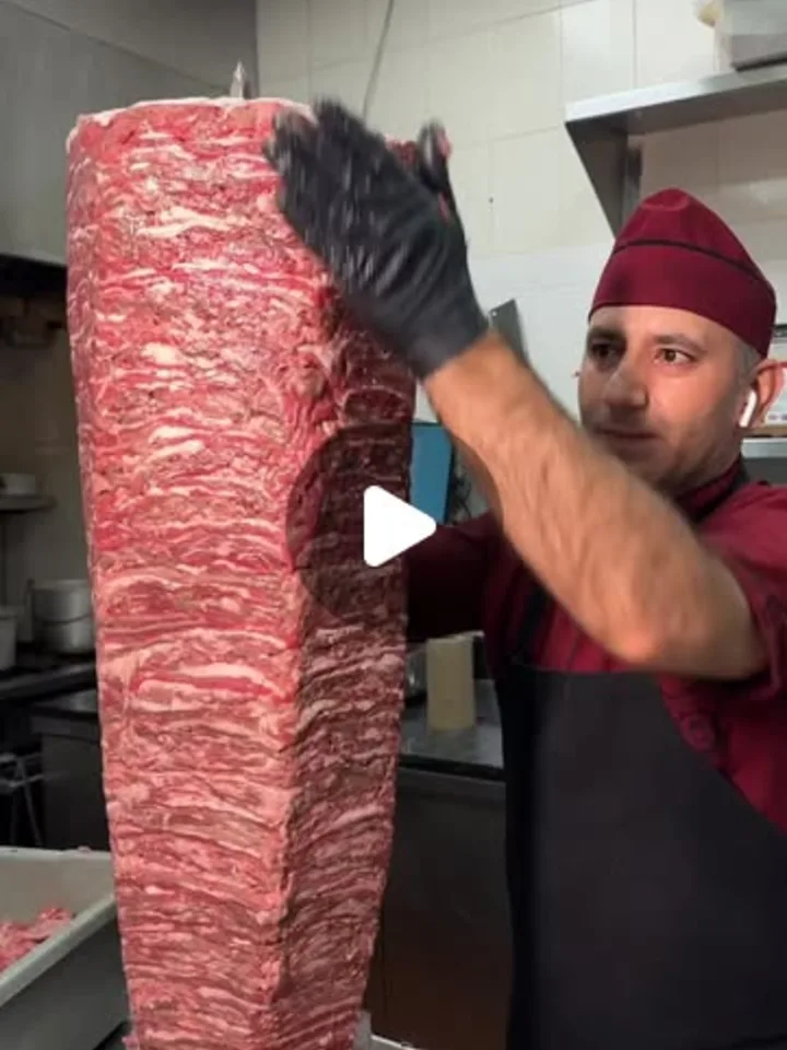 A Kebab 49 cook stacking the döner by hand
